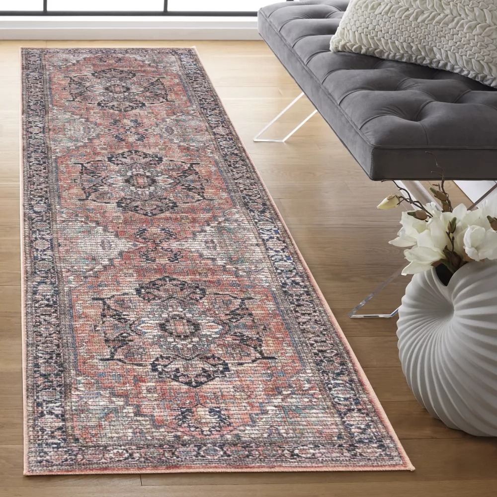 Patterned runner rug in rust and black coloring on hardwood floor.