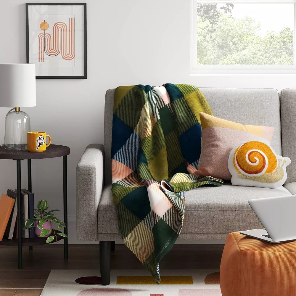 A plaid-patterned blanket on a sofa.