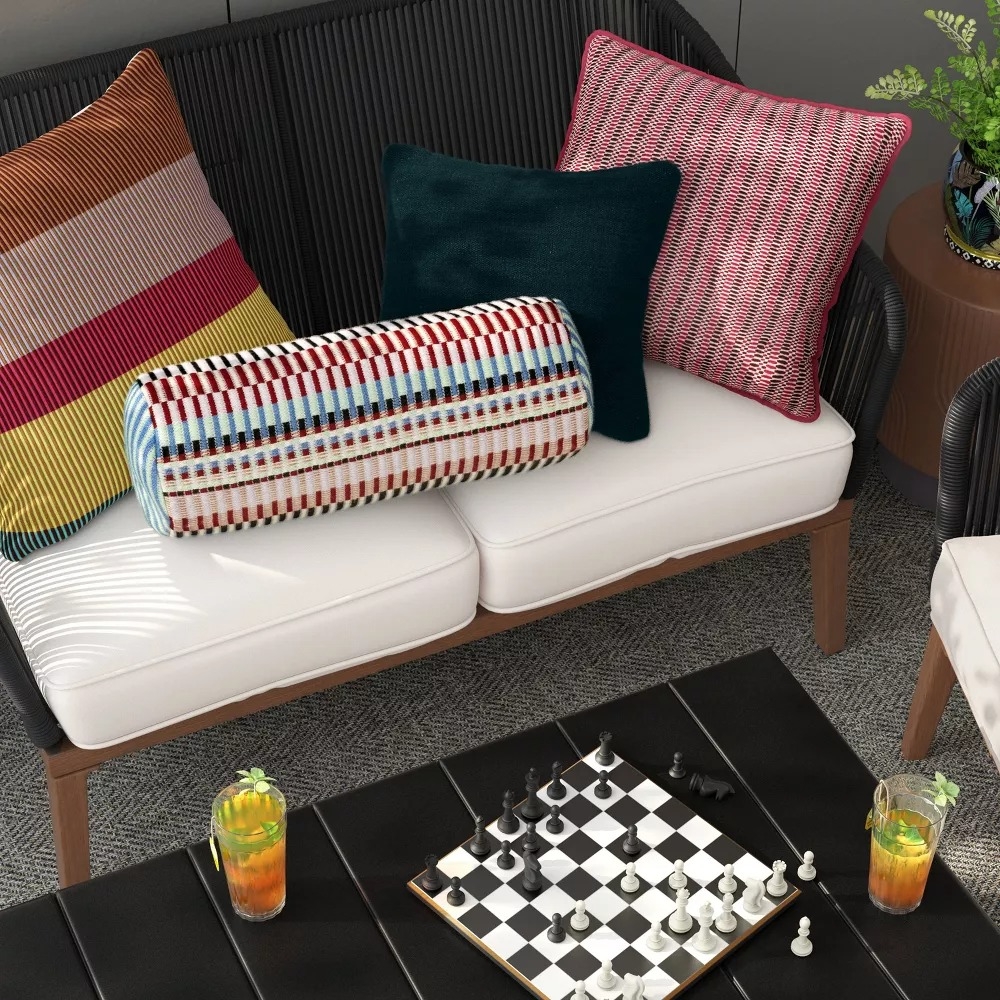 Multicolored patterned pillows on a cushioned bench.
