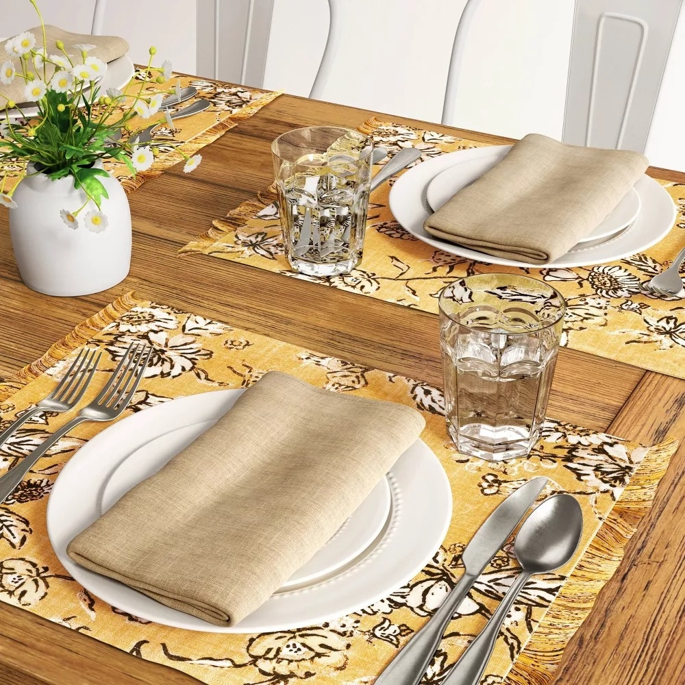 Dining table set with yellow floral placemats.