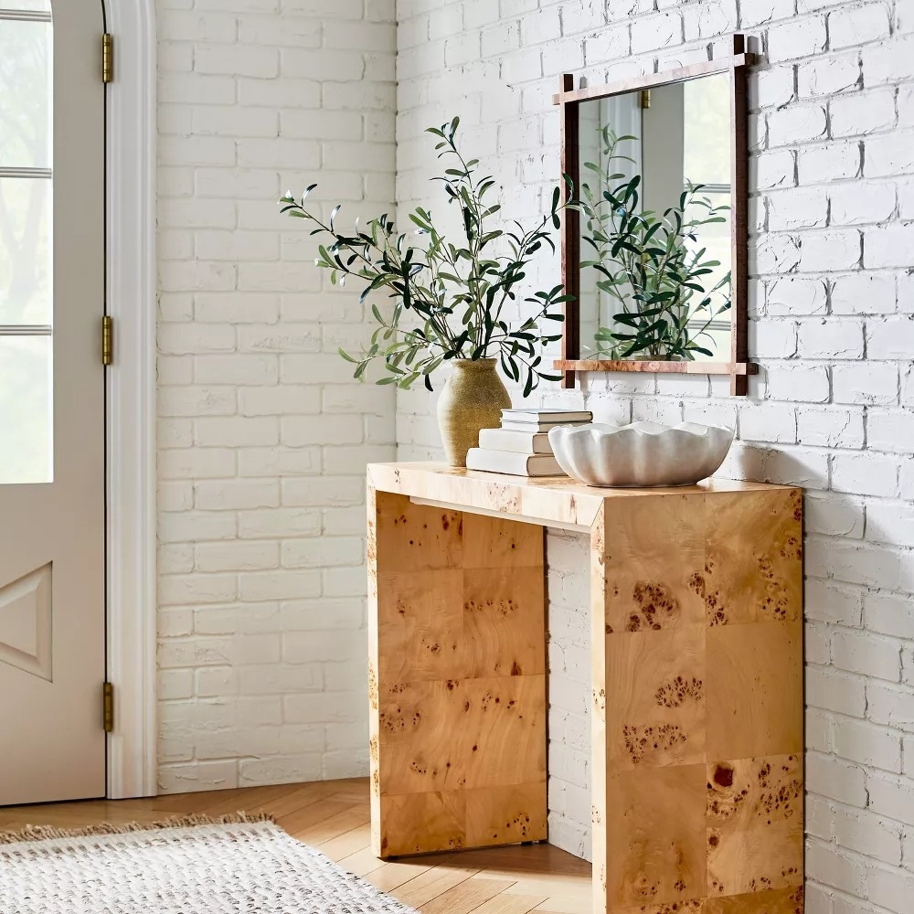 Square wooden console table in an entryway.